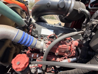 Engine bay of a 2020 Mack GRANITE truck showing red engine components, hoses, and intake tubing in close view.