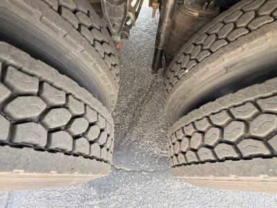 Mack Granite truck rear dual tires view showing tread pattern and gap between wheels with chassis components visible.