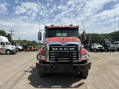 Front view of a red 2020 Mack GRANITE heavy-duty truck with large chrome grille, bumper guard, and side mirrors in a dealership lot.