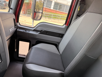 Interior of a Mack Granite truck cab with front passenger seat and door window, showing gray fabric seat, dashboard, and side panel.