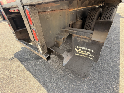 Rear view of a 2020 Mack Granite flatbed truck showing bumper, mudflaps with National Lumber logo, and tail area.