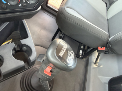 Transmission shifter knob in Mack Granite cab interior with cup holders and seat edge visible.
