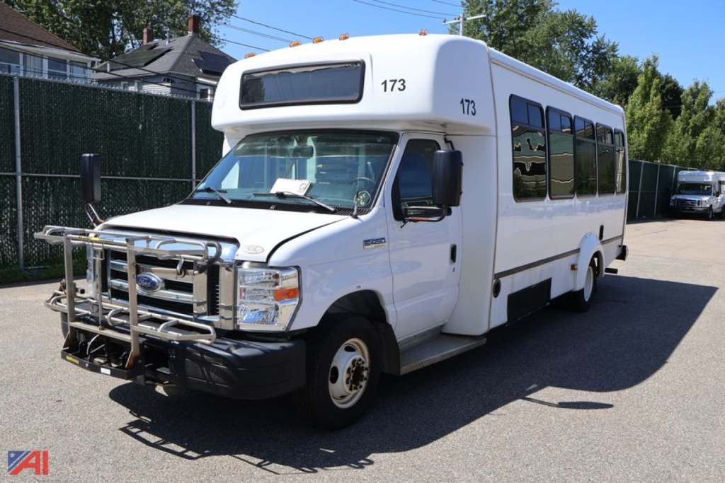 Ford E450 wheelchair bus in white with front bull bar, side windows, and NG natural gas label, number 173 on top; parked outdoors.