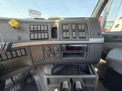 Dashboard and center console of a Volvo VHD64B300 truck cab showing air vent panels, climate controls, radio, and storage compartments.