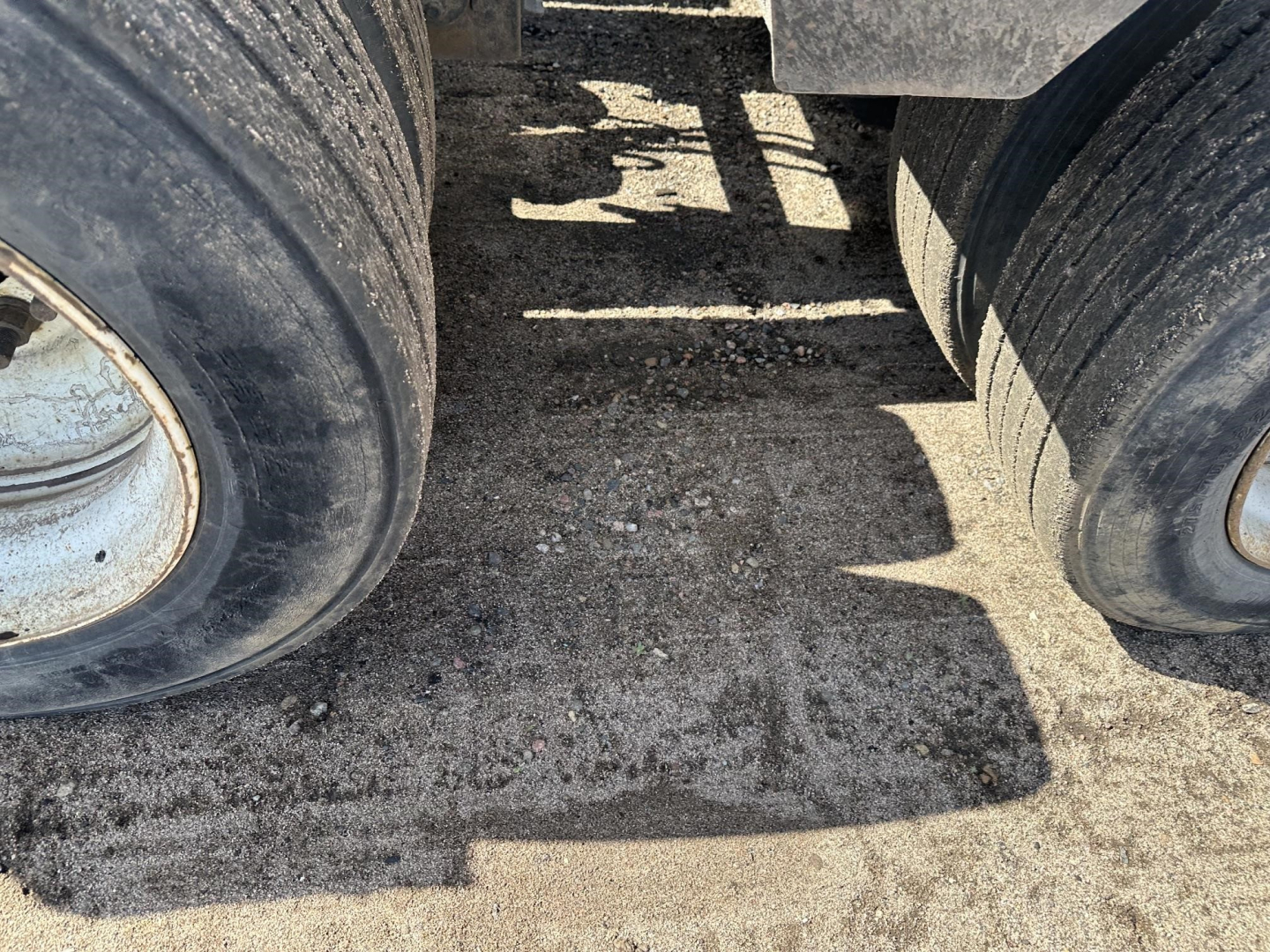 Trailer axles and dual tires undercarriage view showing Load King lowboy equipment and heavy-duty suspension.