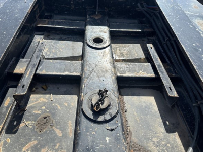Trailer deck of a Load King lowboy showing central crown ring and mounting slots with dirt and wear.