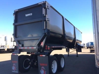 Ranco ED85-42 dump trailer viewed from side rear showing black metallic surface and dual-axle wheels.