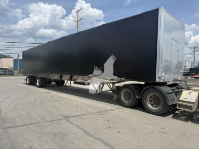 Curtainside trailer showing long black side panels and rear hatch, triple-axle undercarriage, Benson Conestoga trailer. VIN 1TTF532A7P3350337 visible in listing context.
