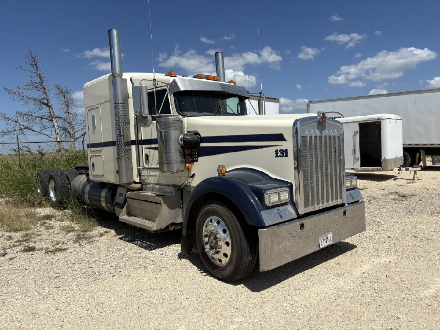 Kenworth W900 conventional sleeper truck, front three-quarter view with large chrome grille, dual air intakes, and tall exhaust stacks.
