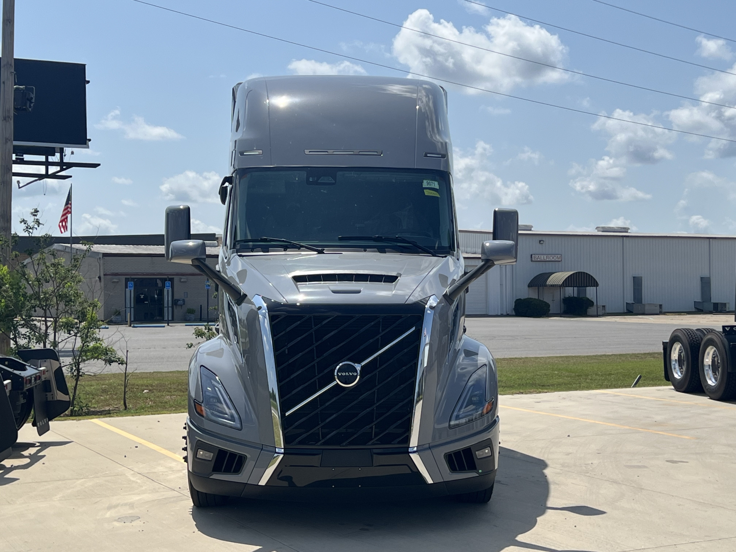 Front view of a new Volvo VNL64T860 conventional sleeper truck showing chrome grille, Volvo emblem, large headlights, and aerodynamic bumper.