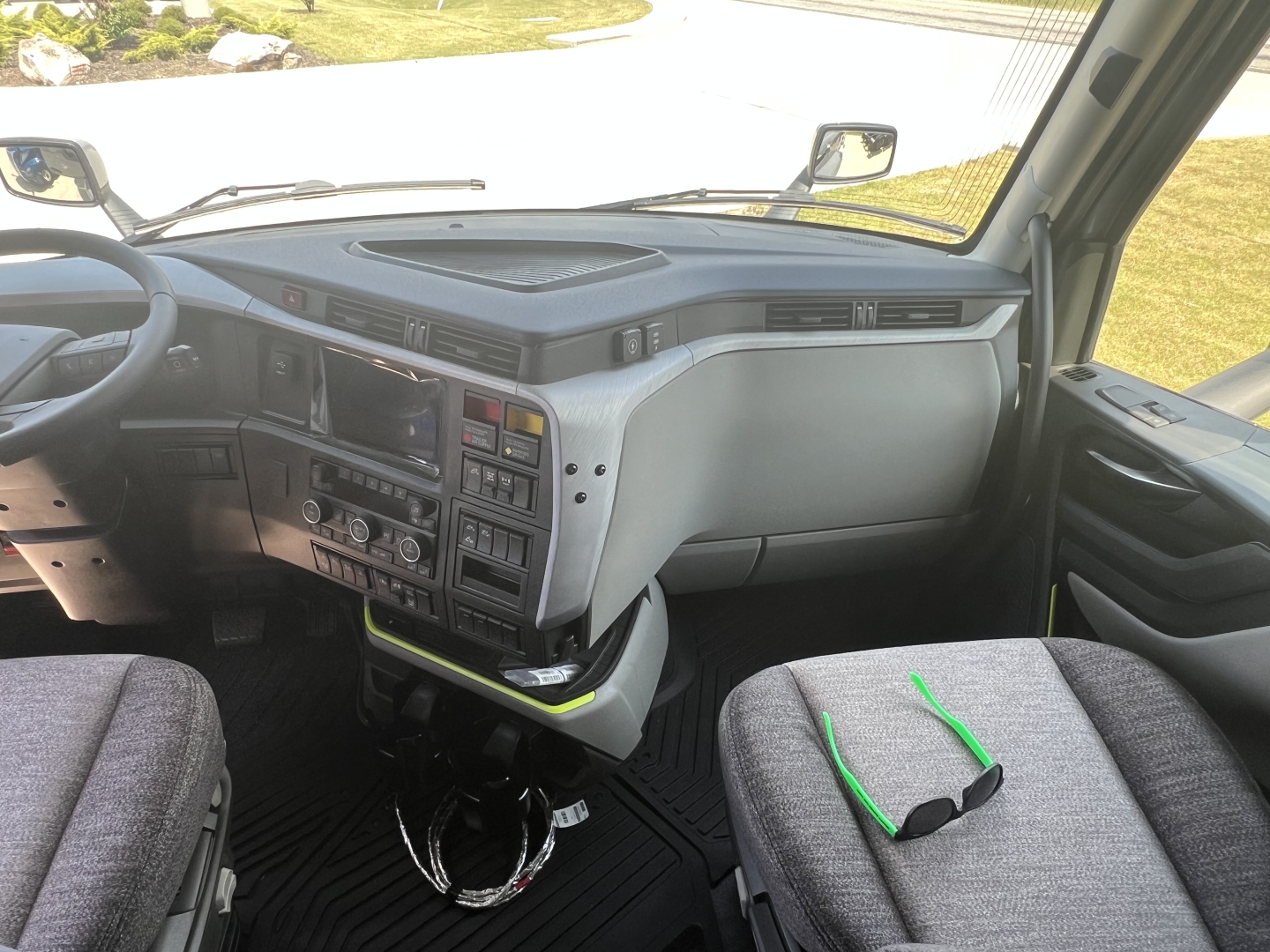 Volvo VNL64T860 truck interior dashboard and front seats with center console, steering wheel, and ignition area visible.