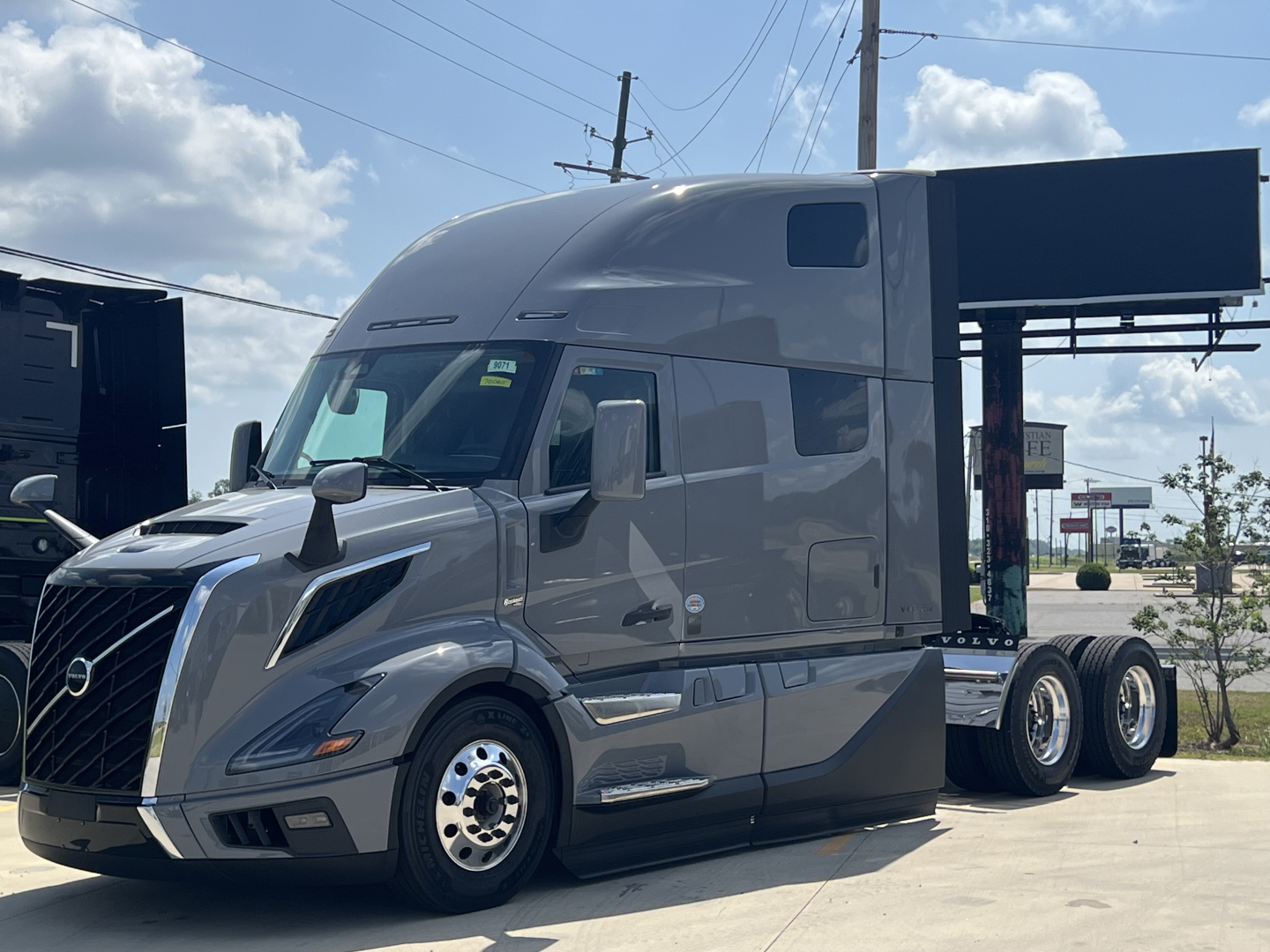 Volvo VNL64T860 tractor-trailer cab in gray, three-quarter front view, with sleeper cab and chrome wheels.