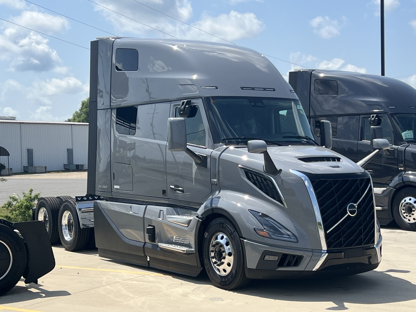 Volvo VNL64T860 tractor cab in view showing sleeper, chrome grille, large side mirrors, and dual rear axles.