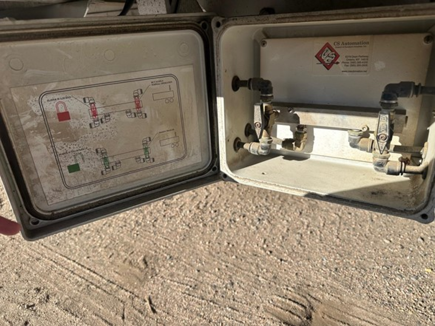 Aluminum drop deck trailer rear showing access panel with schematic, two valves, and labeling plate.