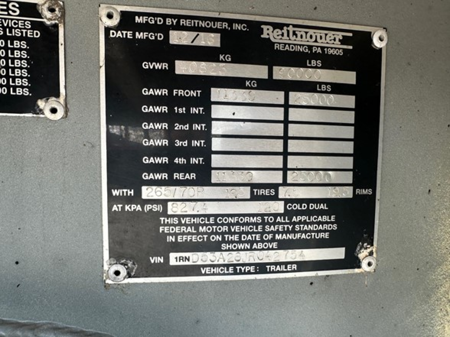 Trailer plate on a 2018 Reitnouer Maxmiser aluminum drop deck showing VIN, GVWR, GAWR, and tire information area.