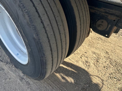 Trailer wheel close-up showing dual rear tires and suspension mount on a 2018 Reitnouer Maxmiser aluminum drop deck trailer.