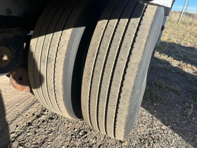 Trailer wheelset with multiple stacked tires on an aluminum drop deck trailer, part of a 2018 Reitnouer Maxmiser. visible tire treads and rim area.