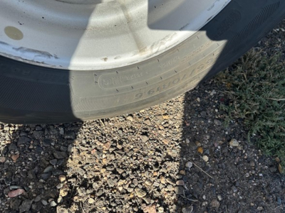 Rear wheel and tire of a trailer showing branding markings on the tire sidewall.