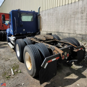 Freightliner Columbia 120 conventional truck chassis showing rear view with dual rear axles and mud flaps, blue cab, rusted frame, no body on trailer hitch area.