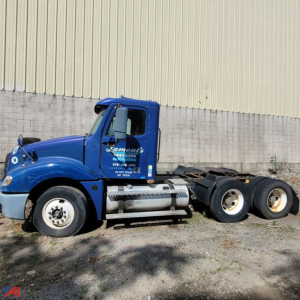 Truck cab and chassis of a blue Freightliner Columbia 120 conventional daycab in a parts-only listing. Side view shows cab with text and fuel tanks, rear wheels and axle set.