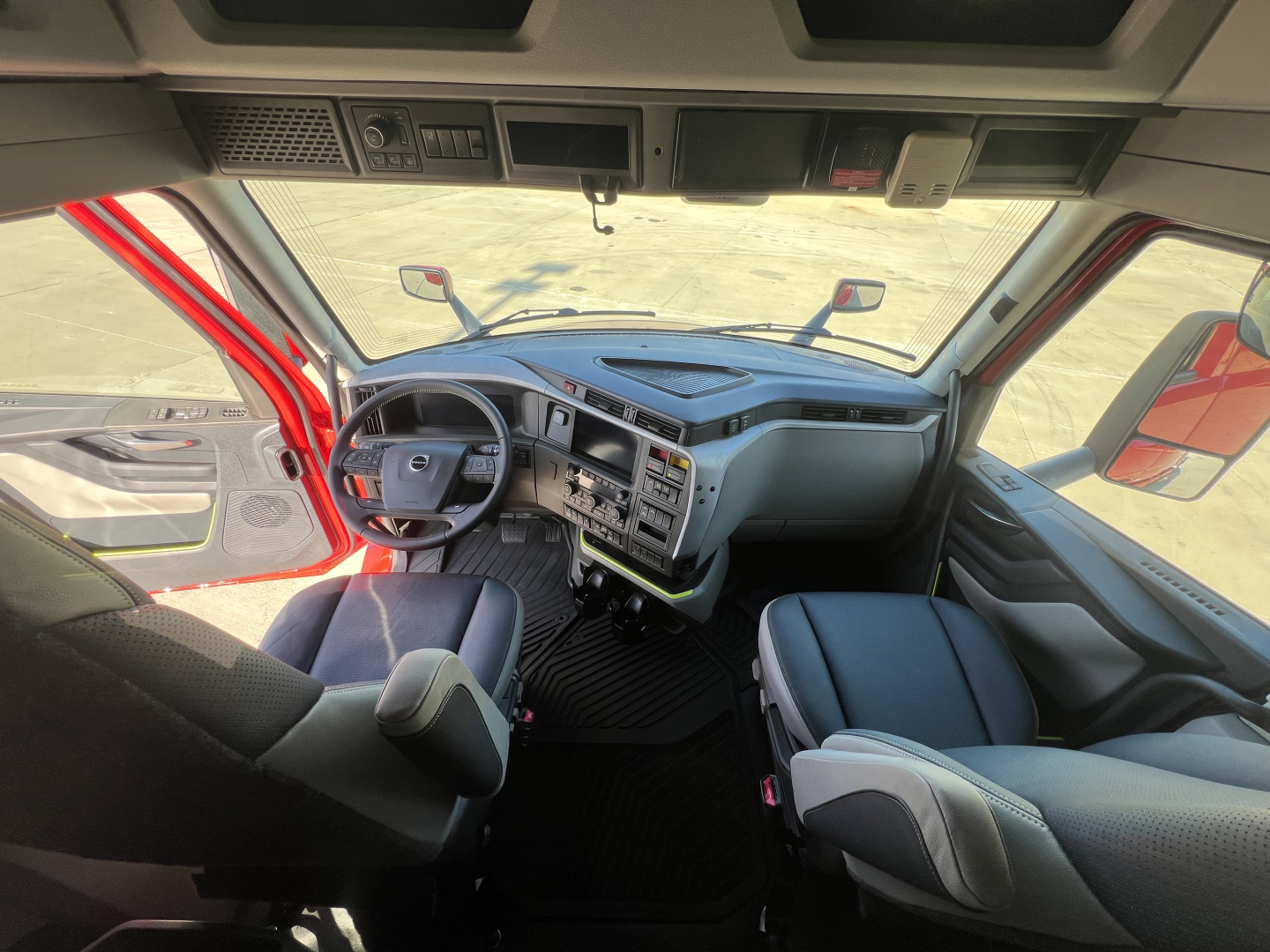 Volvo VNL64T660 truck cabin interior showing driver seat with steering wheel and dashboard controls.