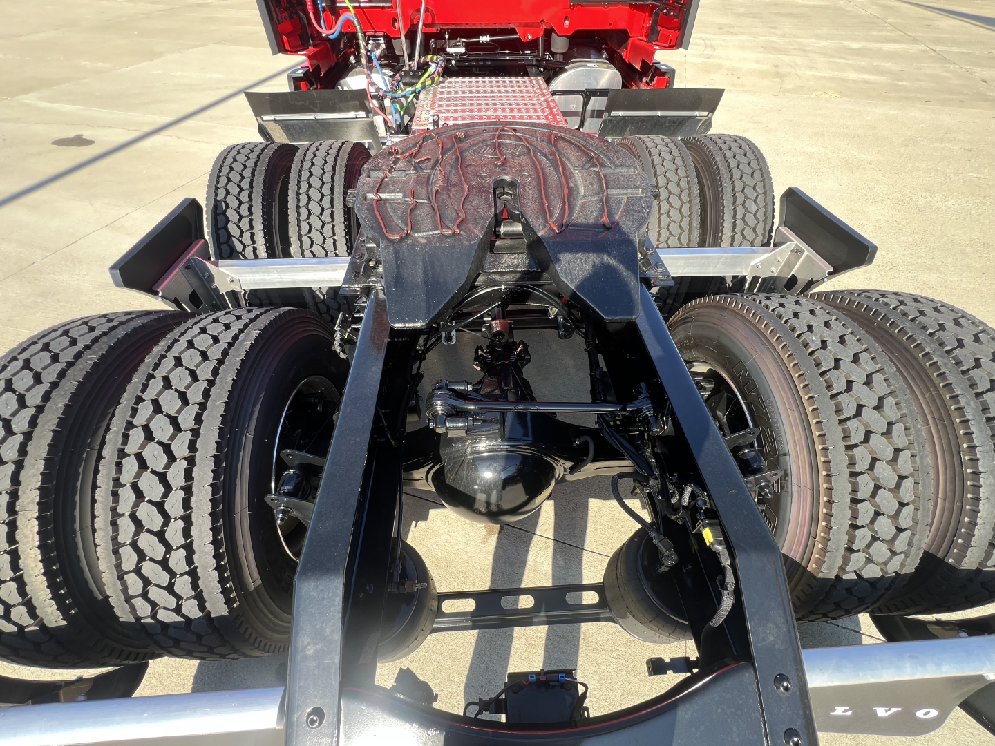 Volvo VNL64T660 truck chassis view showing rear dual axles, drivetrain, and fifth-wheel area with tires and suspension components.