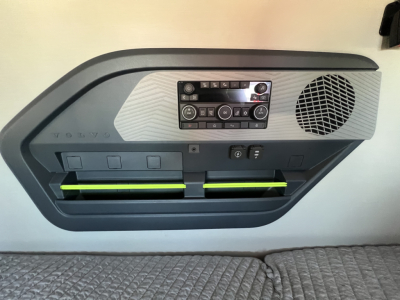 Volvo VN door panel showing control cluster and storage pockets with speaker grille