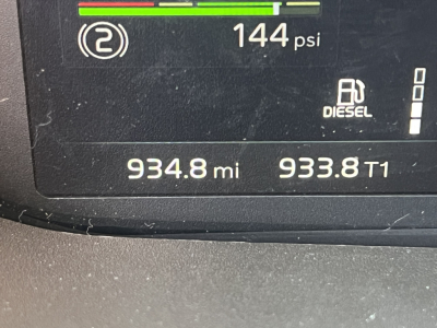 Dashboard display showing 144 psi, diesel icon, two fuel gauges, and odometer readings 934.8 mi and 933.8 mi, along with VIN-related information.