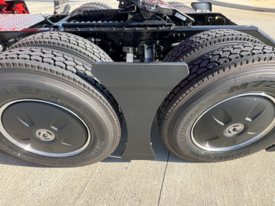 Dual rear axles of a Volvo truck with heavy-duty tires and a central differential housing. Visible text on tires shows M+S pattern, wheel rims with hubcaps.