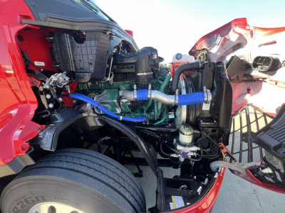 Volvo VNL64T660 engine bay showing diesel engine with blue silicone hoses, radiator, and surrounding components.