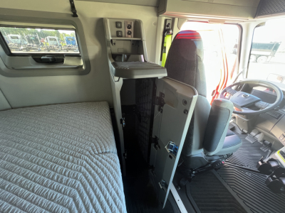 Volvo VNL tractor cab interior showing sleeper area and driver seat with controls and trim.