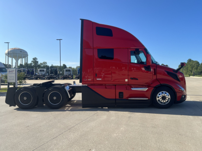 Volvo VNL64T660 truck cab side profile showing red exterior, sleeper cab, tandem rear axles, and aerodynamic design.