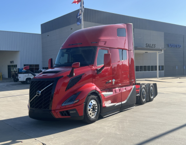 Volvo VNL64T660 truck in red, three-quarter view showing tractor with sleeper cab and dual rear axles.