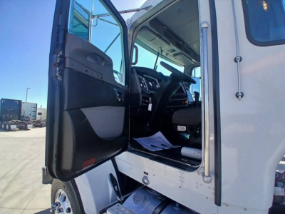 Kenworth T800 truck cab interior visible through open driver door with steering wheel and dashboard; seating and cab entry area shown.