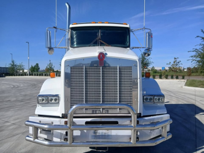 Kenworth T800 conventional sleeper truck front view showing large chrome grille and bumper, dual mirrors, and badge at center.