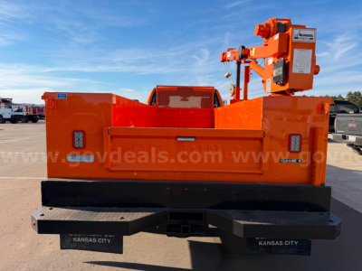 Ram 3500 service utility bed with crane, rear view showing bright orange body and Kansas City mud flaps.