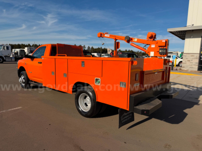 Orange Ram 3500 utility/service truck back view with multiple storage compartments and a mounted boom crane.