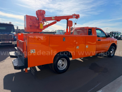 Service/utility truck with an mounted boom lift, orange utility body, side compartments, and rear access. Visible text includes no specific model details; general layout shows crane arm and tool/storage compartments.