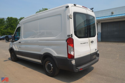 Ford Transit van cargo vehicle rear three-quarter view with rear doors closed, 'Transit' badge on right door, black bumper, white paint.