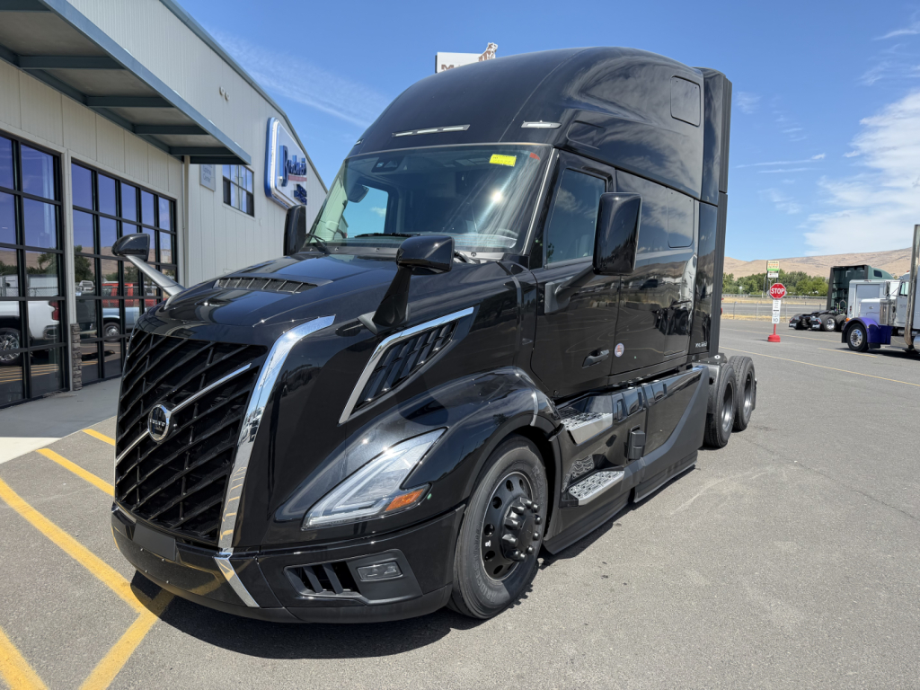 Volvo VNL64T860 tractor-trailer in black exterior, front three-quarter view, showing aerodynamic hood, grille, headlights, and large sleeper cab with rooftop airflow device.