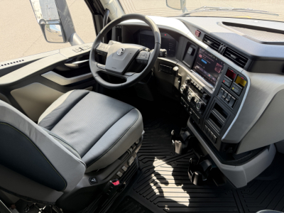 Volvo VNL64T860 interior cabin showing steering wheel, dashboard touchscreen, center console, and driver seat.