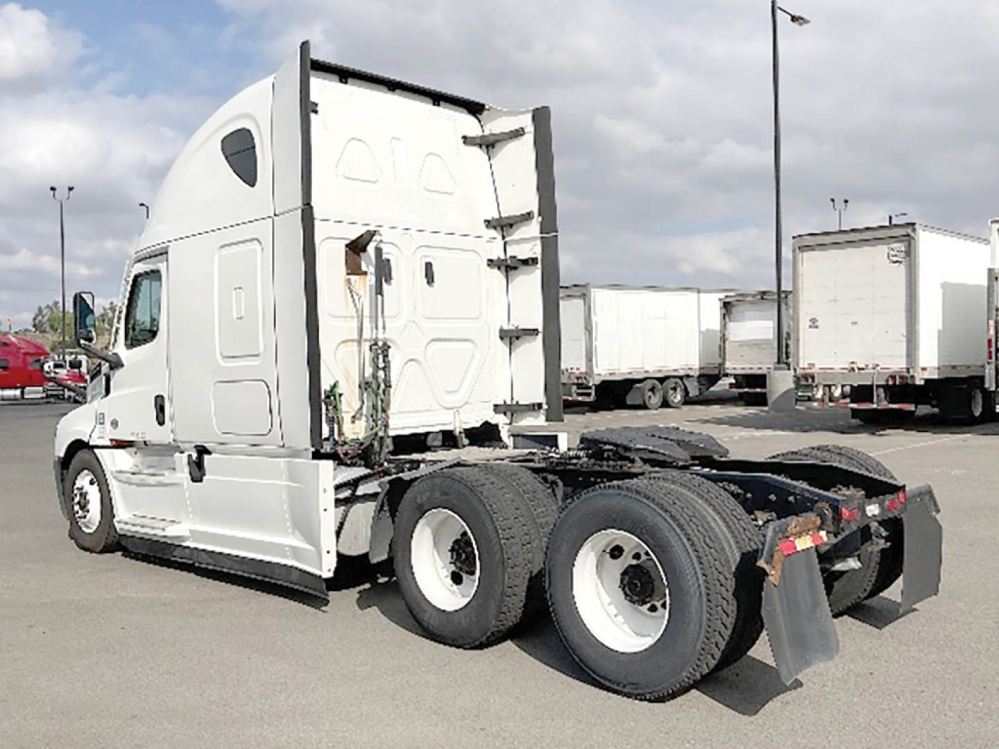 Freightliner Cascadia126 tractor-trailer cab and attached rear axle viewed from side showing sleeper cab and tandem axles.