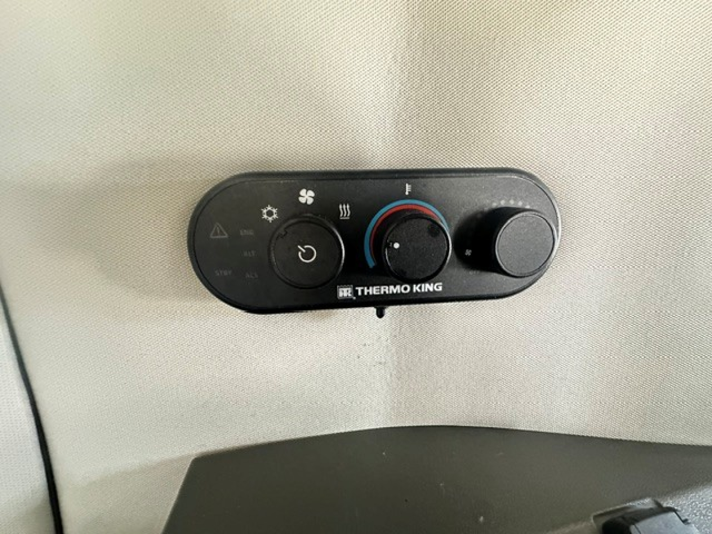 Thermo King climate control panel in a Volvo VNL cabin showing fan, temperature dial, defrost button, and vent controls.