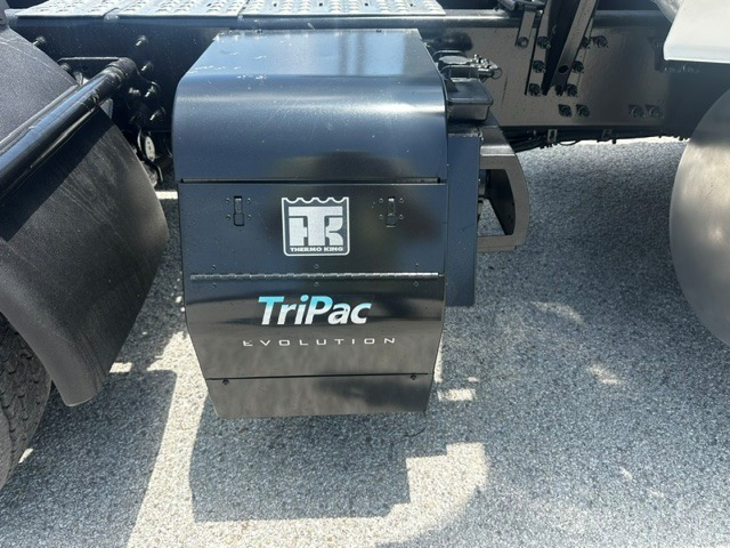 Rear view of Volvo VNL truck with TriPac Evolution auxiliary power unit under the sleeper area, showing TriPac Evolution branding on the APU housing.