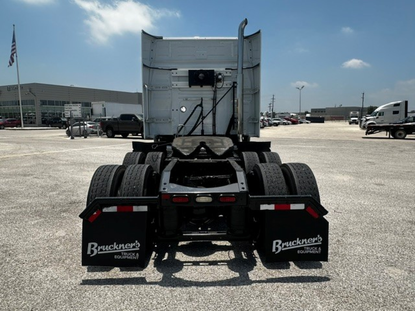Volvo VNL64T740 tractor rear showing fifth wheel and dual rear axles with mud flaps and Bruckner's mud flaps.