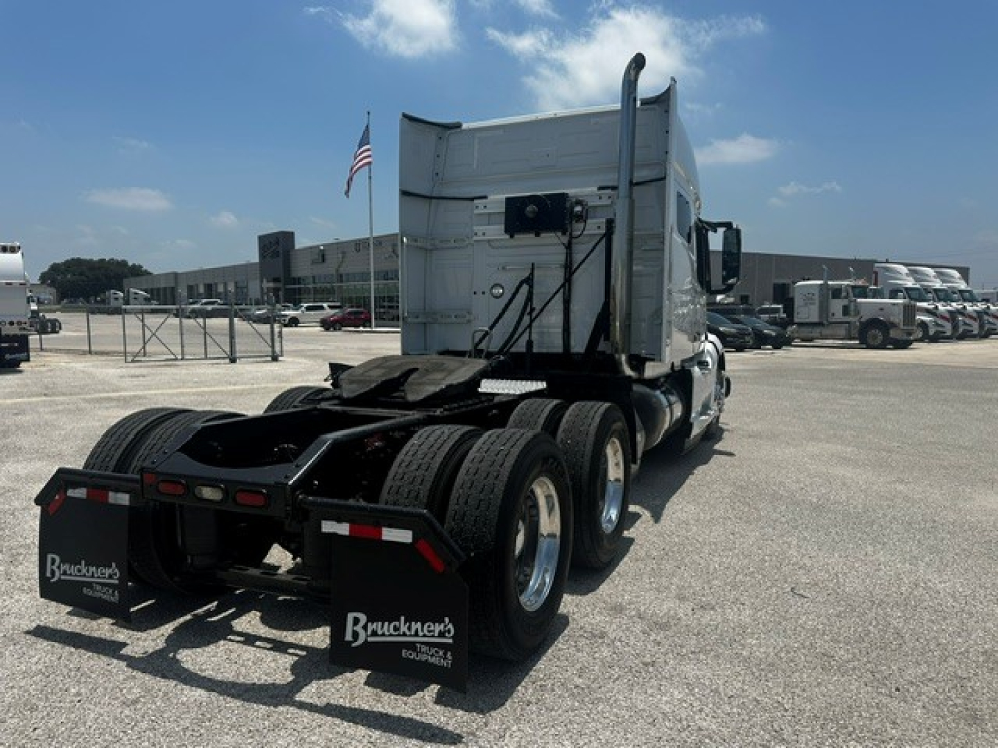 Truck tractor rear and sleeper cab shown from behind with dual rear axles and mud flaps.