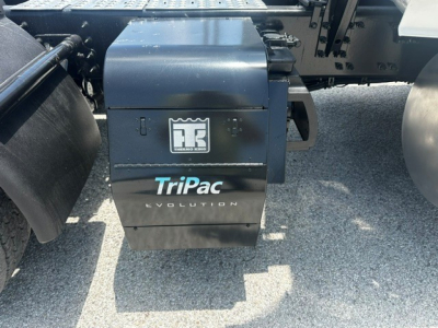 Rear view of Volvo VNL truck with TriPac Evolution auxiliary power unit under the sleeper area, showing TriPac Evolution branding on the APU housing.