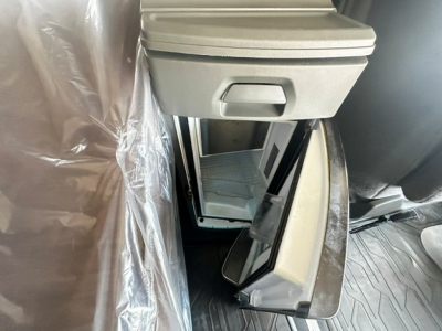 Volvo VNL64T740 interior center console with storage drawer and cup holders, view of open compartments and dash area.
