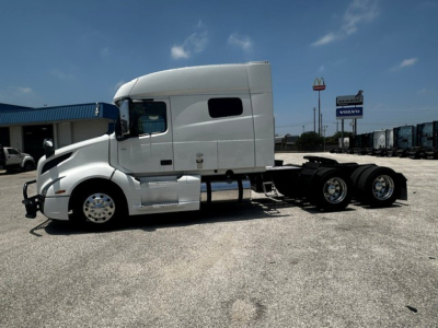 Volvo VNL64T740 tractor in side view showing cab and chassis with 3 axle configuration.