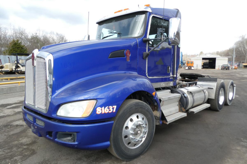 Blue Kenworth T660 tractor showing front grille and side with 81637 numbers and chrome exhaust, highway truck in yard